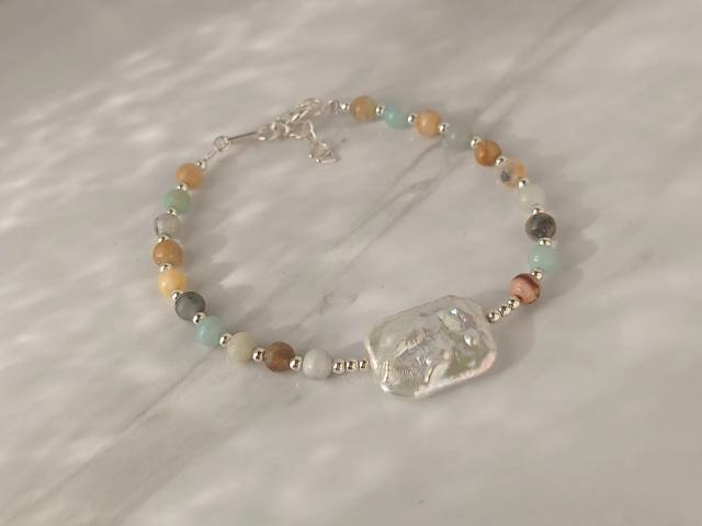 Pulsera diseñada en Plata 925 con piedras naturales y perlas de rio natural central 